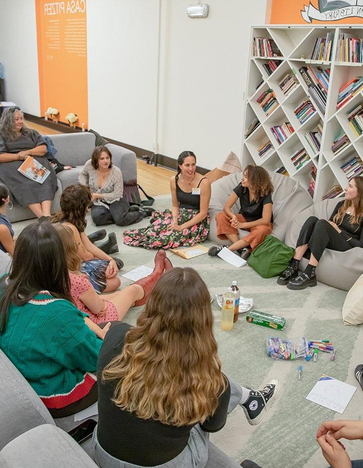 A group sits on the ground in a circle at CASA Pitzer